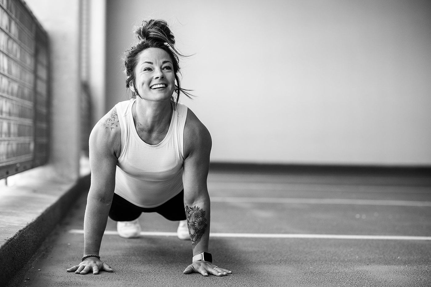 Ashley smiling in a push-up position, black and white