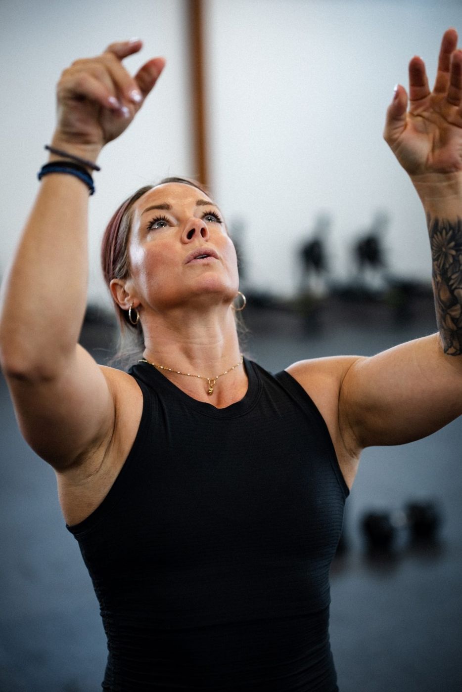 Ashley reaching overhead mid-workout